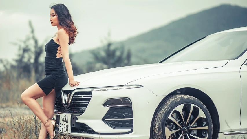 a woman in a black dress standing next to a white car, a picture, trending on cg society, in style of lam manh, touareg, background image, ultra wide-shot