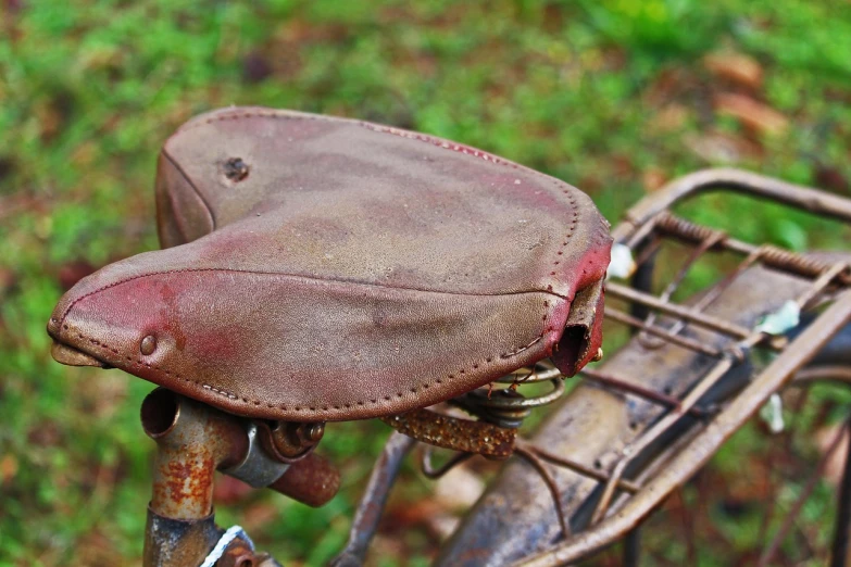 a close up of a bicycle with a saddle, flickr, stained dirty clothing, covered, postprocessed, taken with canon 8 0 d