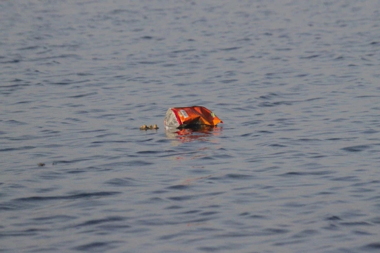 a life jacket floating on top of a body of water, by Mathias Kollros, flickr, hurufiyya, soda cans, gulf of naples, crashed, 6 : 3 0 am