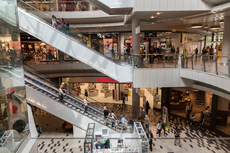 a couple of escalators that are in a building, by Matthias Stom, shutterstock, lots of shops, people at work, melbourne, wide long view