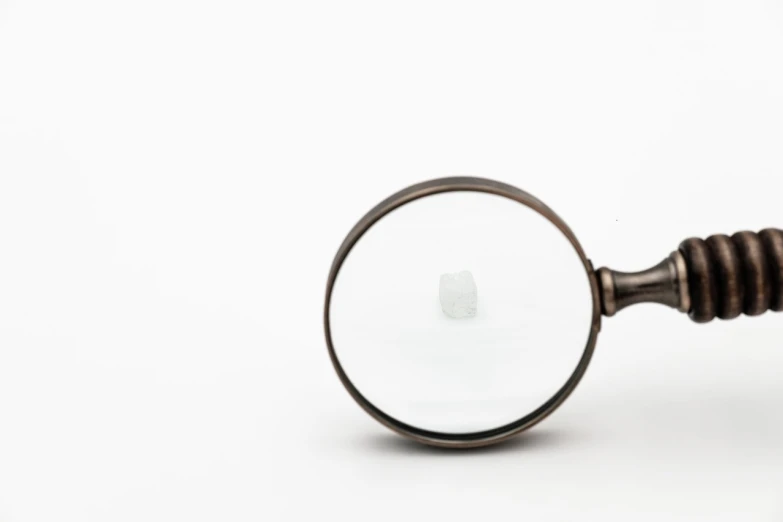 a close up of a magnifying glass on a white surface, inspired by Vija Celmins, mingei, offering the viewer a pill, close up of single sugar crystal, 4 k product photo, small rectangular glasses