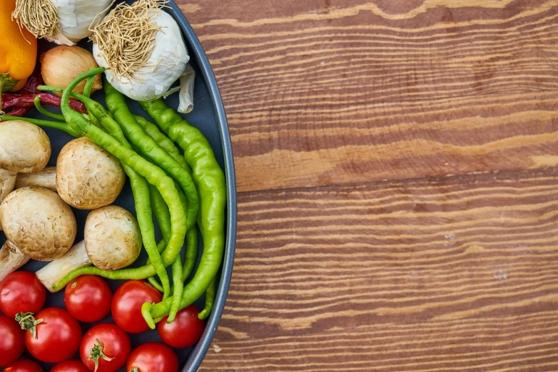 a bowl of vegetables sitting on top of a wooden table, a picture, pexels, green and red, banner, high res photo, offering a plate of food