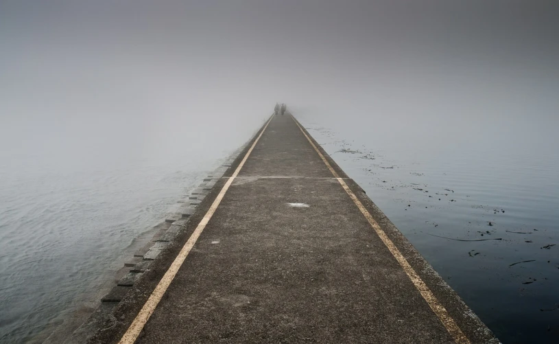 a long pier in the middle of a body of water, a picture, by Joze Ciuha, postminimalism, wet road, mist art of illusion, pareidolia, paved