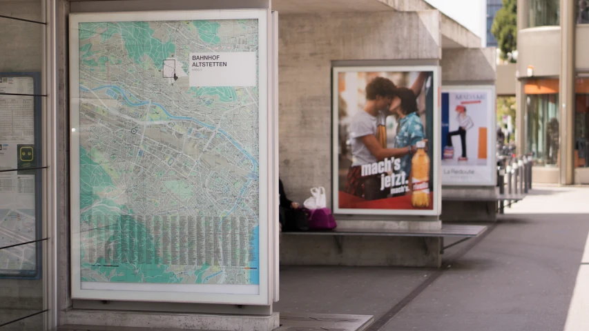 a couple of benches sitting next to each other on a sidewalk, a poster, by Margaret Leiteritz, arbeitsrat für kunst, map cartography, drinking a beer at train station, close-up shot from behind, digital billboard in the middle