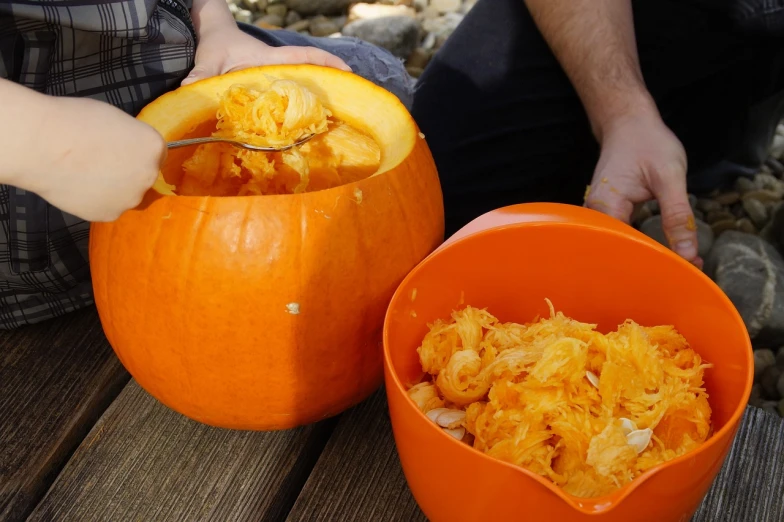 a couple of pumpkins sitting on top of a wooden table, process art, chopping hands, tastes, filling with water, stringy