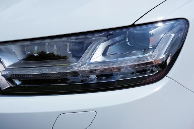 a close up of a headlight on a white car, glass oled visor head, detailed zoom photo, accurate and detailed, not cropped