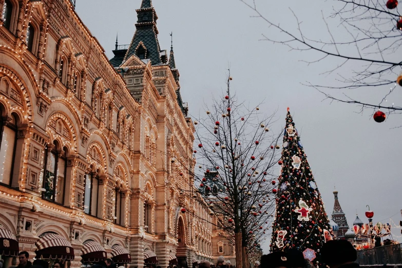 a large building with a christmas tree in front of it, a photo, by Marie Bashkirtseff, tumblr, red square, 🎀 🧟 🍓 🧚, hunting, header text”