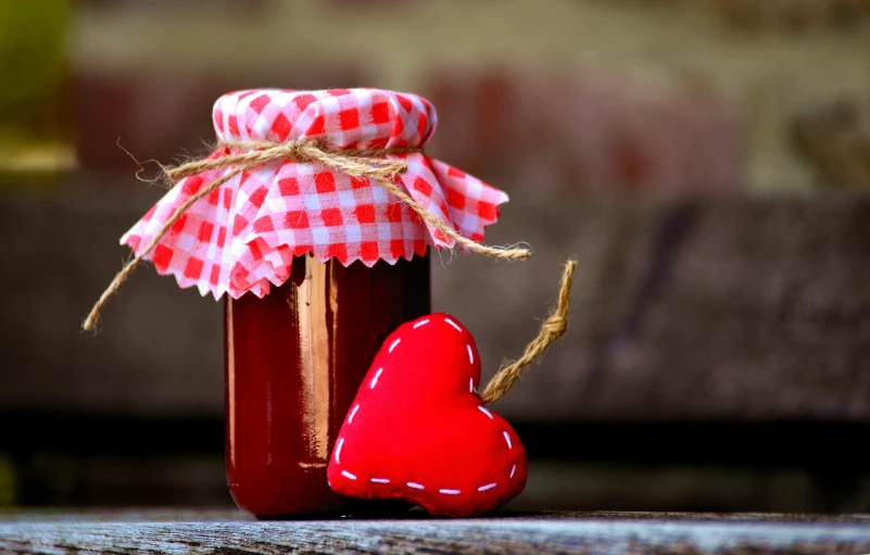 a jar of jam with a heart next to it, pexels, visual art, red-fabric, warm and joyful atmosphere, varnished, stylized photo