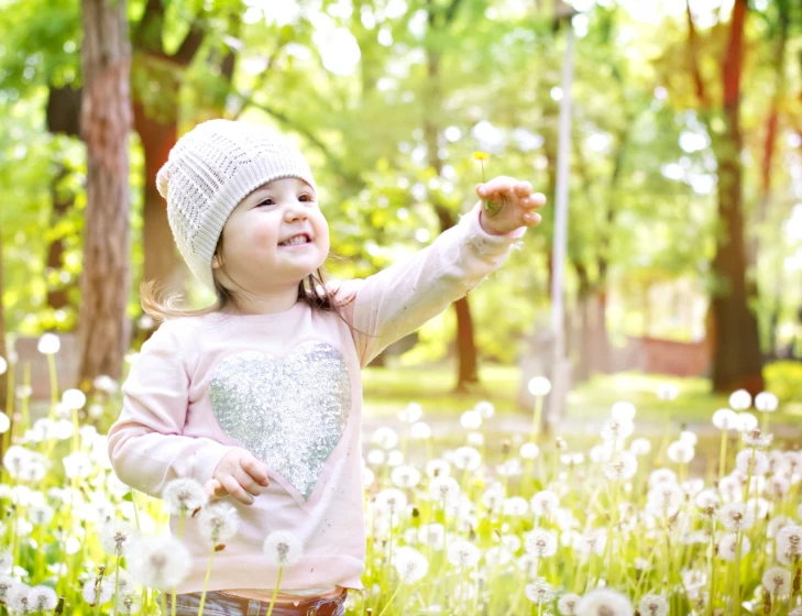 a little girl standing in a field of dandelions, a picture, shutterstock, sunny day in a park, waving, packshot, outdoor photo