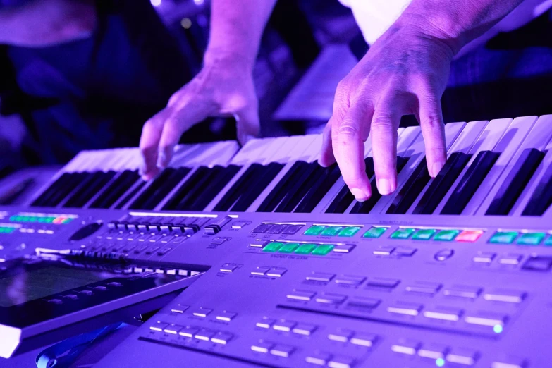 a close up of a person playing a musical instrument, by Andrei Kolkoutine, synthetism, purple scene lighting, keyboardist, panels, high dynamic range