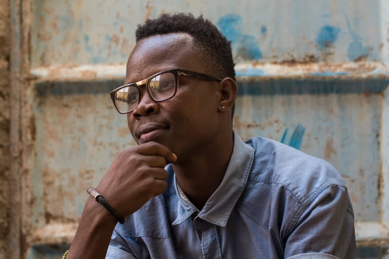 a close up of a person wearing glasses, by Willian Murai, sitting down casually, portrait of a rugged young man, pondering, osborne macharia