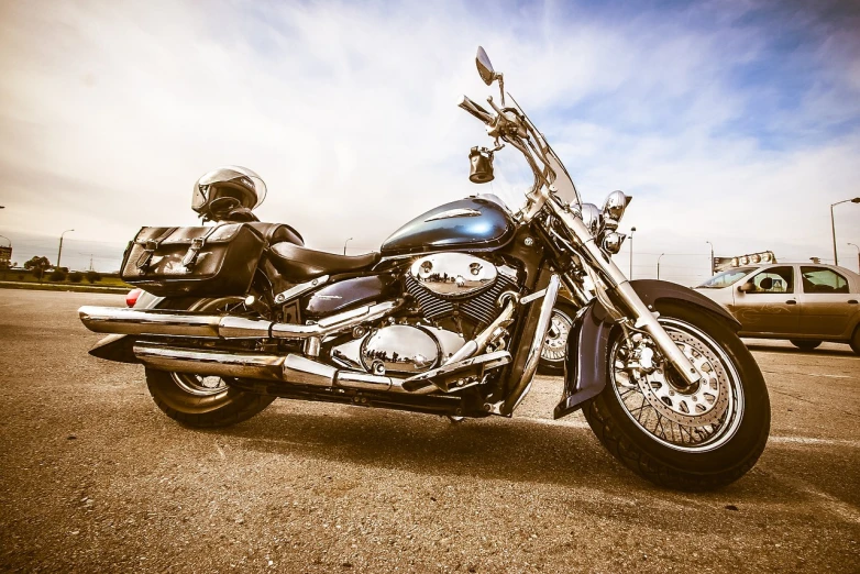 a motorcycle is parked in a parking lot, a picture, by Jens Søndergaard, pixabay, photorealism, blue and silver colors, leather armored, bright sky, stock photo