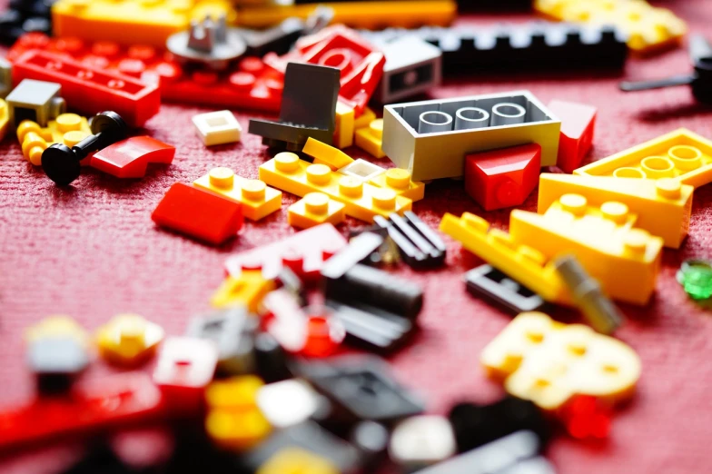 a pile of legos sitting on top of a table, a picture, constructivism, hq 4k phone wallpaper, yellow and red color scheme, super detail of each object, broken toys are scattered around