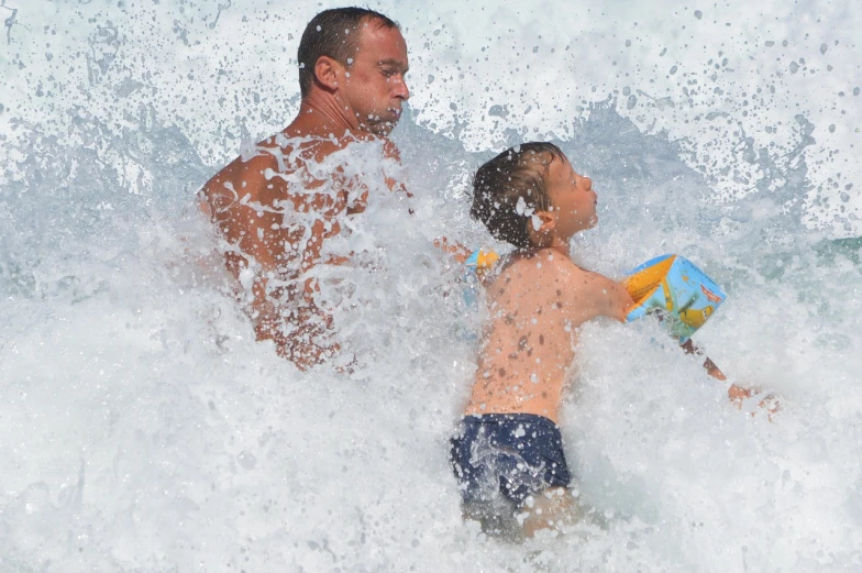 a man and a child playing in the water, dangerous waves, feature, manly, afp