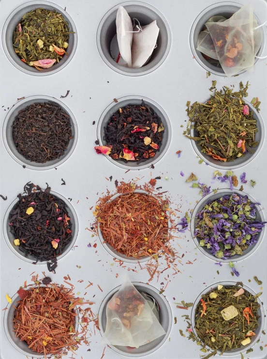 a muffin tin filled with lots of different types of tea, a picture, by david rubín, pexels, process art, plant specimens, 1 6 x 1 6, multi - coloured, vessels