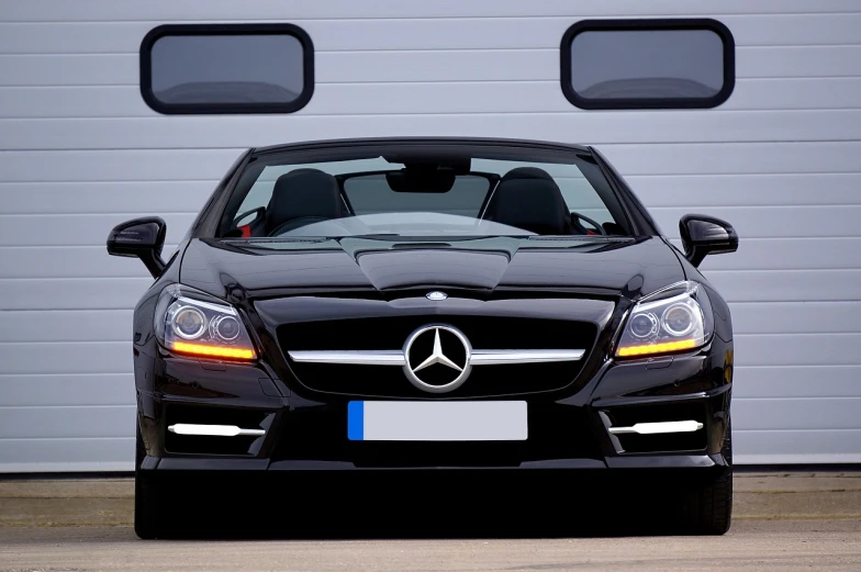 a car parked in front of a garage door, by Niko Henrichon, trending on pixabay, mercedez benz, transparent black windshield, convertable, front flash