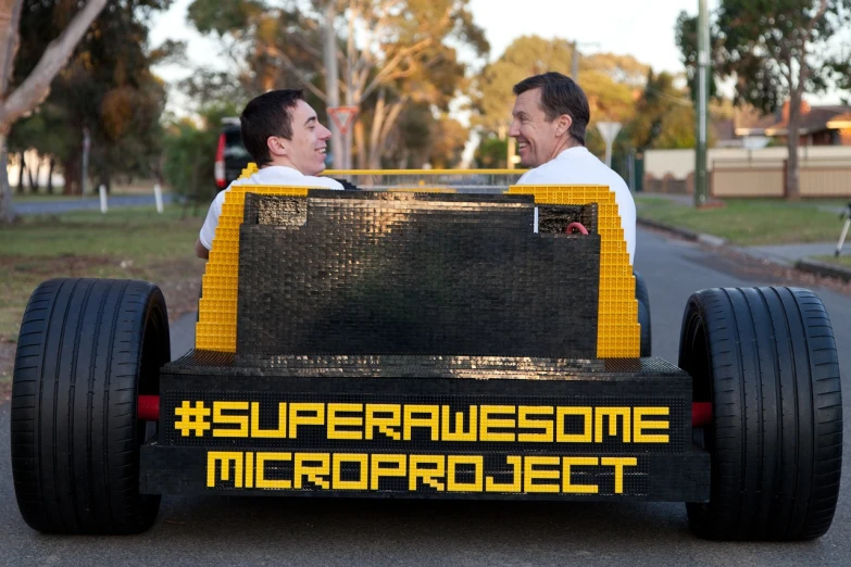 two men sitting in the back of a lego car, inspired by Seb McKinnon, tumblr contest winner, the microchip, superhero cape, proud, cover shot