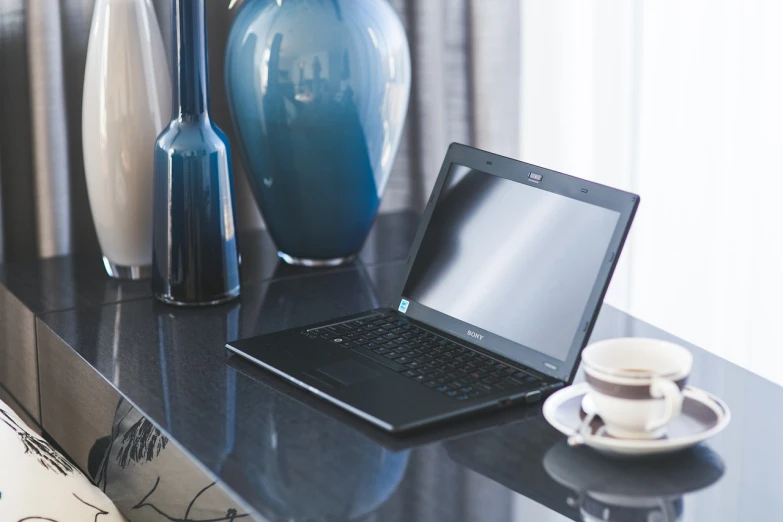 a laptop computer sitting on top of a black table, by Joy Garnett, elegant atmosphere, avalon, soft natural lighting, on display