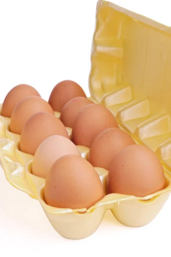 a carton filled with eggs sitting on top of a table, by Maeda Masao, shutterstock, isolated on white background, 2 0 1 0 photo, recipe, close up