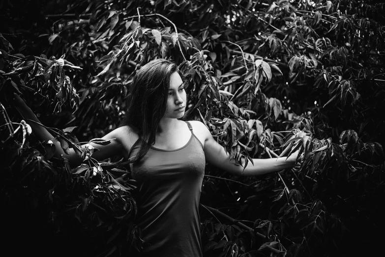 a black and white photo of a woman holding a frisbee, featured on cgsociety, amongst foliage, young sensual woman, in a tree, 4 k glamour photography
