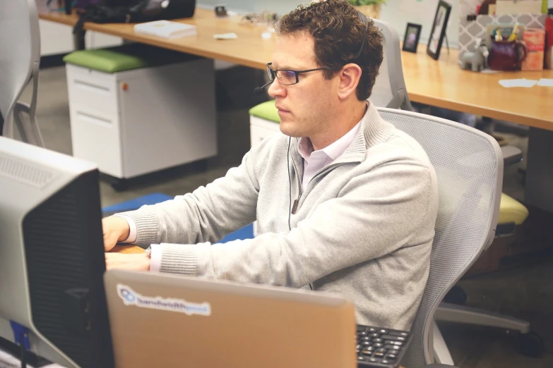 a man sitting at a desk in front of a computer, by Matt Cavotta, vp of marketing, carefully designed, hq ”