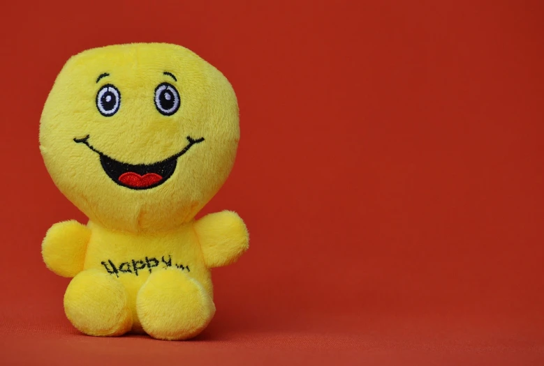 a yellow stuffed animal with a happy face, a picture, by Tom Carapic, trending on pixabay, figuration libre, in red background, hey buddy, with a beautifull smile, squishy