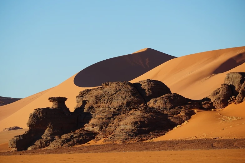 a large rock formation in the middle of a desert, by Dietmar Damerau, shutterstock, dunes, telephoto shot, late afternoon, cape