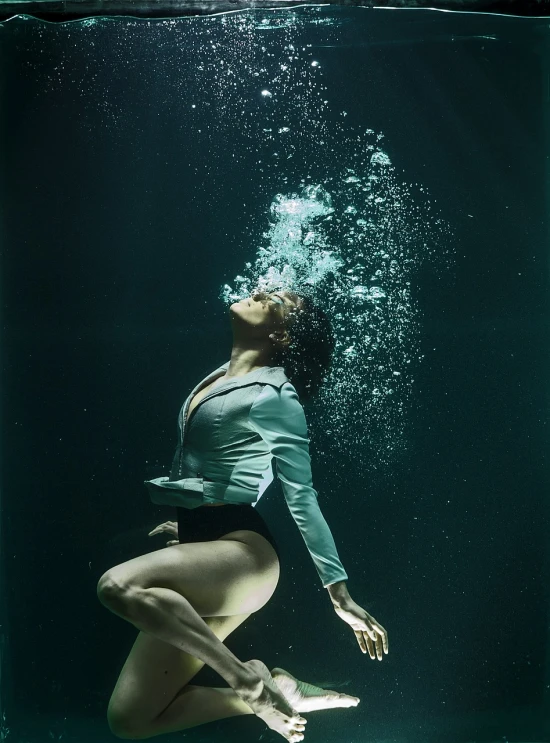 a woman in a bathing suit dives under water, a portrait, by Maciej Kuciara, conceptual art, dynamic dance photography, water particle in front, ripley scott, clothes floating