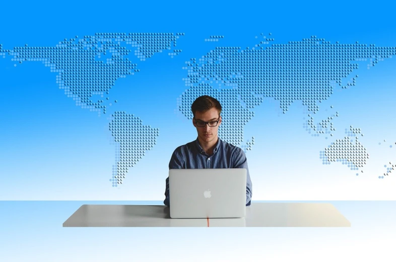 a man sitting in front of a laptop computer, pexels, computer art, world map, man with glasses, some people are sitting, with a blue background