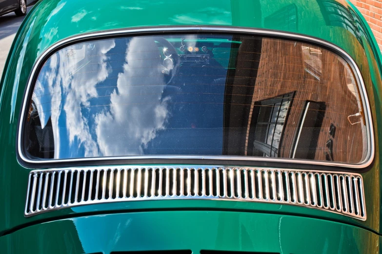 a green car parked in front of a brick building, inspired by Vivian Maier, precisionism, 1 9 7 0 s car window closeup, marvellous reflection of the sky, muscle cars, helmet view