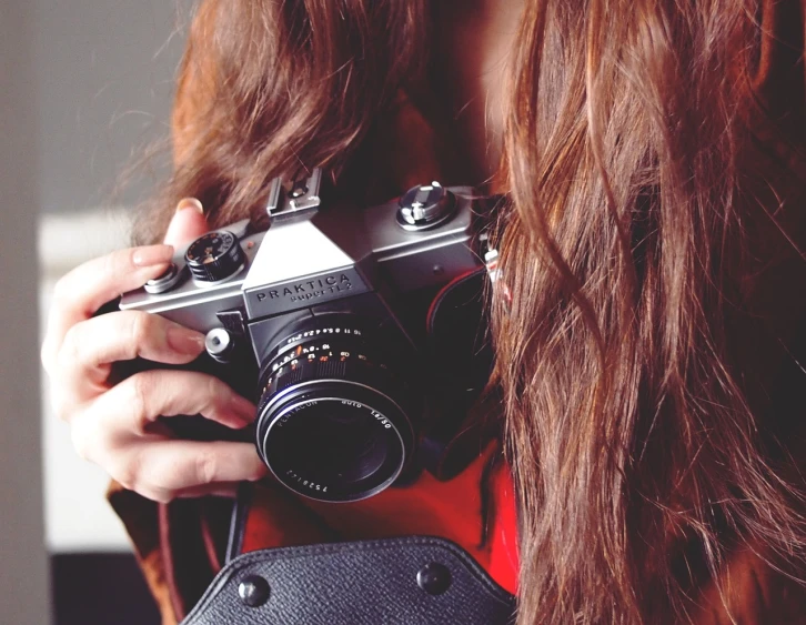 a close up of a person holding a camera, inspired by Elsa Bleda, girl with brown hair, half body photo, half - length photo, petite