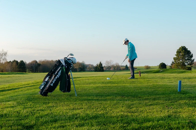 a man standing on top of a lush green field, clubs, practice, 🕹️ 😎 🚬, ground angle