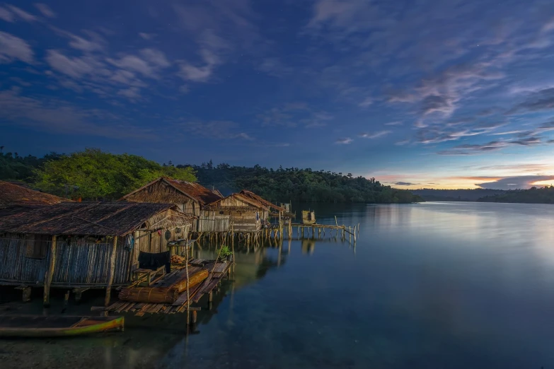 a group of houses sitting on top of a body of water, by Erik Pevernagie, shutterstock, sumatraism, peaceful evening harbor, rustic, abandoned, wooden