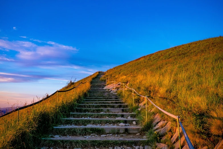 a set of stairs leading to the top of a hill, a stock photo, by Erwin Bowien, shutterstock, late summer evening, post processed 4k, ireland, vivid vibrant colors