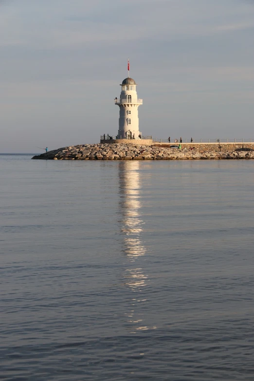 a lighthouse in the middle of a body of water, a picture, by Andrei Kolkoutine, tallinn, istockphoto, reflected light, harbour