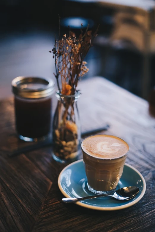 a cup of coffee and a spoon on a table, unsplash, small hipster coffee shop, warm atmosphere, aussie baristas, amazingly composed image