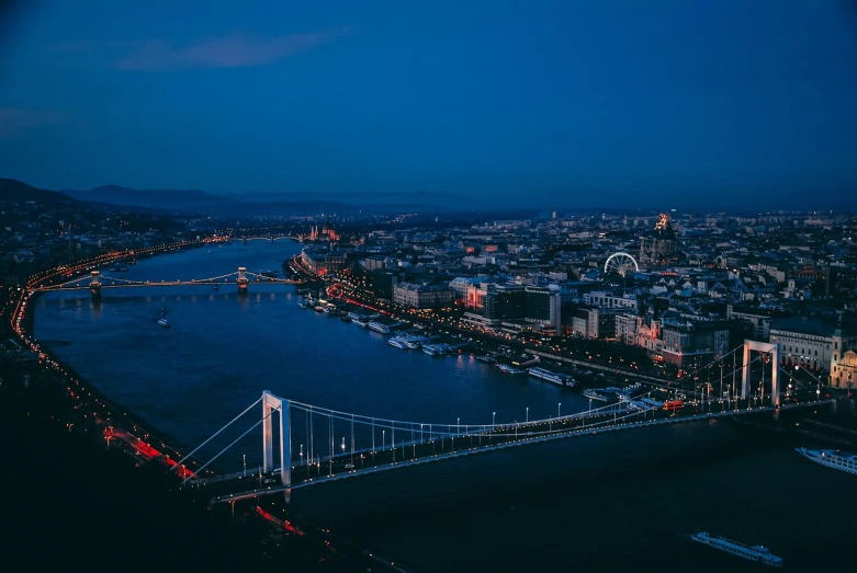 an aerial view of a city at night, a picture, by Adam Szentpétery, pexels contest winner, bridge, twilight ; wide shot, blue night, austro - hungarian