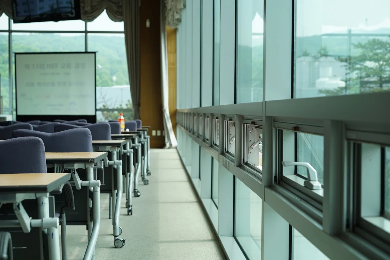 a classroom with rows of desks and a projector screen, by Yi Jaegwan, flickr, modernism, glass railing, landscape vista, cornell, rows of doors