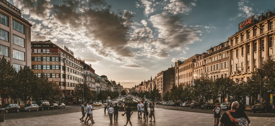 a group of people walking down a street next to tall buildings, a picture, by Matija Jama, unsplash contest winner, prague in the background, on a great neoclassical square, summer evening, clouds around