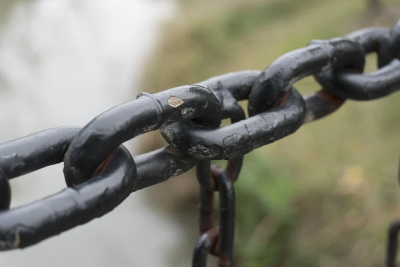 a close up of a chain with a river in the background, a portrait, wrought iron, high detail product photo, blockchain, grungy steel