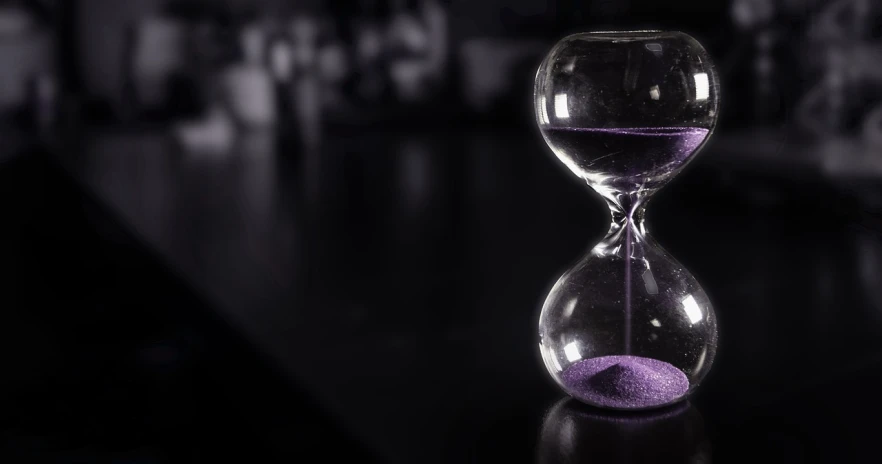 a hourglass sitting on top of a table, pexels, process art, black and purple, shot on nikon z9, time is running out, programming