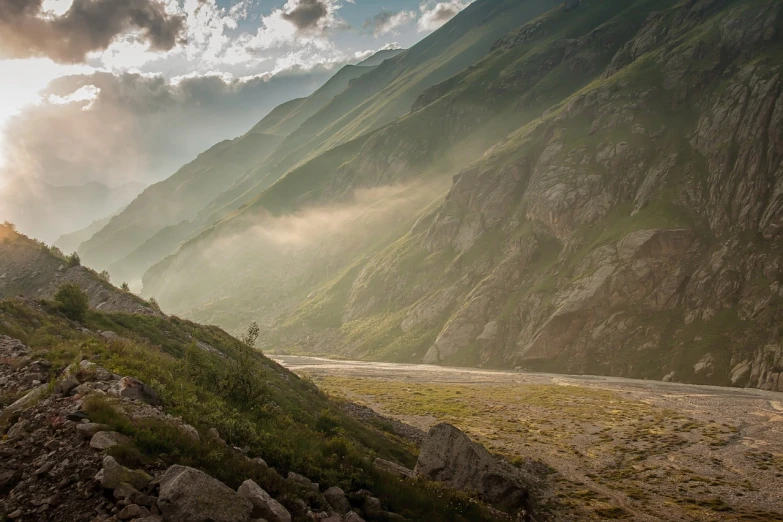 a person riding a horse on the side of a mountain, by Werner Andermatt, pexels contest winner, romanticism, the morning river, ground covered in mist, georgic, filtered evening light