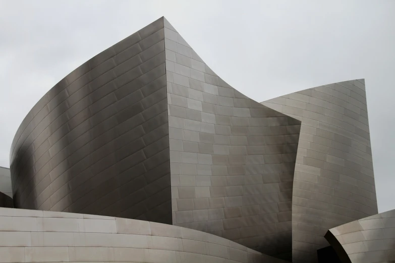 a close up of a building on a cloudy day, modernism, disneyland background, grey metal body, curved lines, galaxy