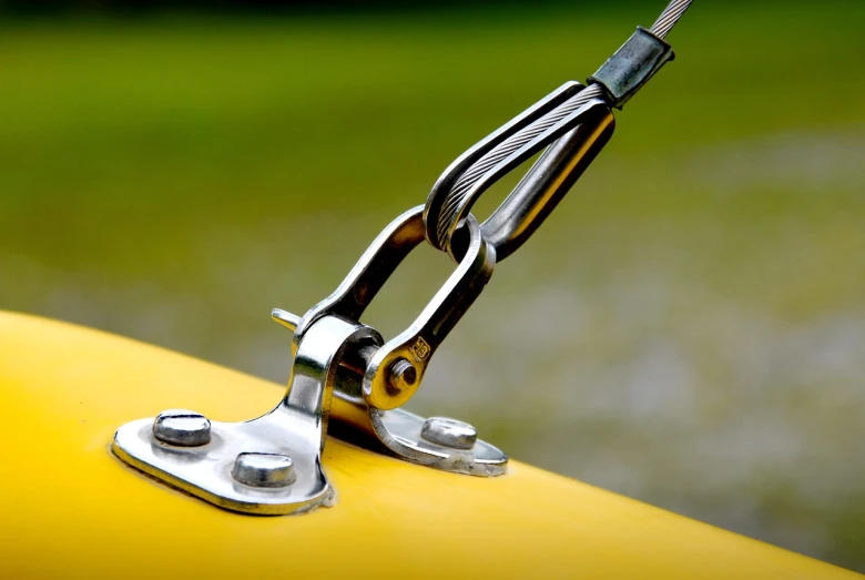 a close up of a handle on a motorcycle, a picture, minimalism, sailing boat, yellow, clamp, stainless steal