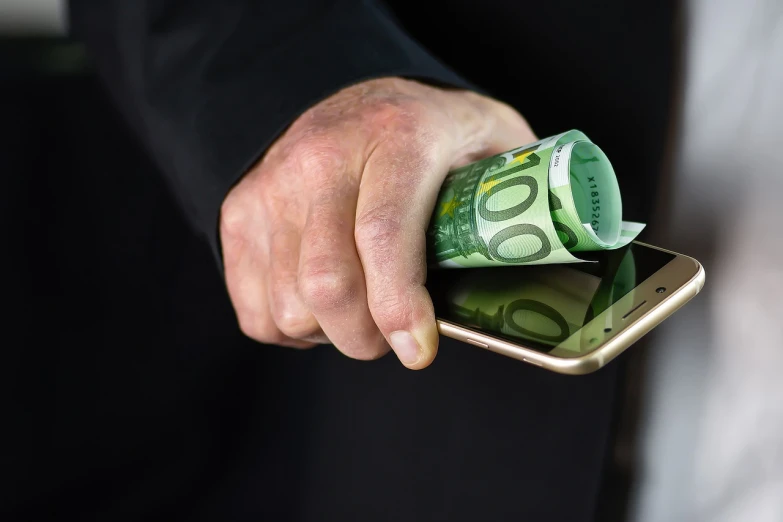 a close up of a person holding a cell phone, a stock photo, by Niko Henrichon, shutterstock, figuration libre, personification of greed, cash, belgium, australian