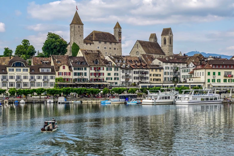 a couple of boats that are in the water, a photo, by Hans Schwarz, shutterstock, renaissance, grossmünster, lots of buildings, ! low contrast!, villages castles