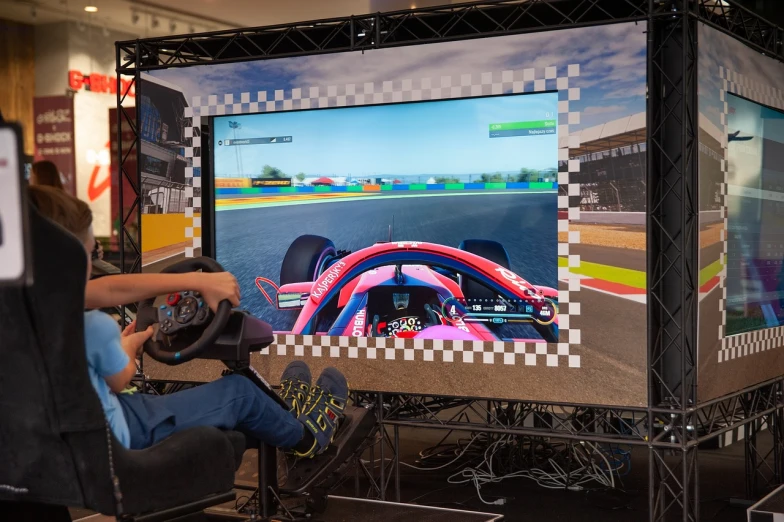 a person sitting in a chair playing a video game, inspired by Hendrick Cornelisz Vroom, shutterstock, truck racing into camera, expo-sure 1/800 sec at f/8, close up to the screen, large scale photo