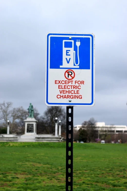 a blue and white sign sitting on the side of a road, a photo, by Joe Stefanelli, shutterstock, hydrogen fuel cell vehicle, with a park in the back ground, mcgill, presidential