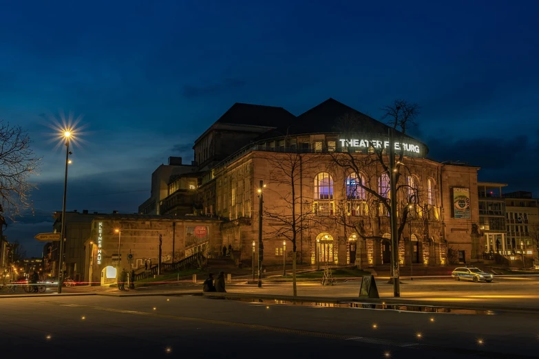 a large building sitting on the side of a road, by Richard Hess, flickr, renaissance, dramatic theater lighting, wide panoramic shot, spring evening, tiffany