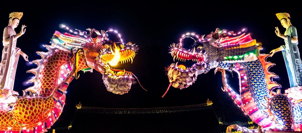 a group of dragon statues lit up at night, interactive art, 360, twins, shot from below, yin yang